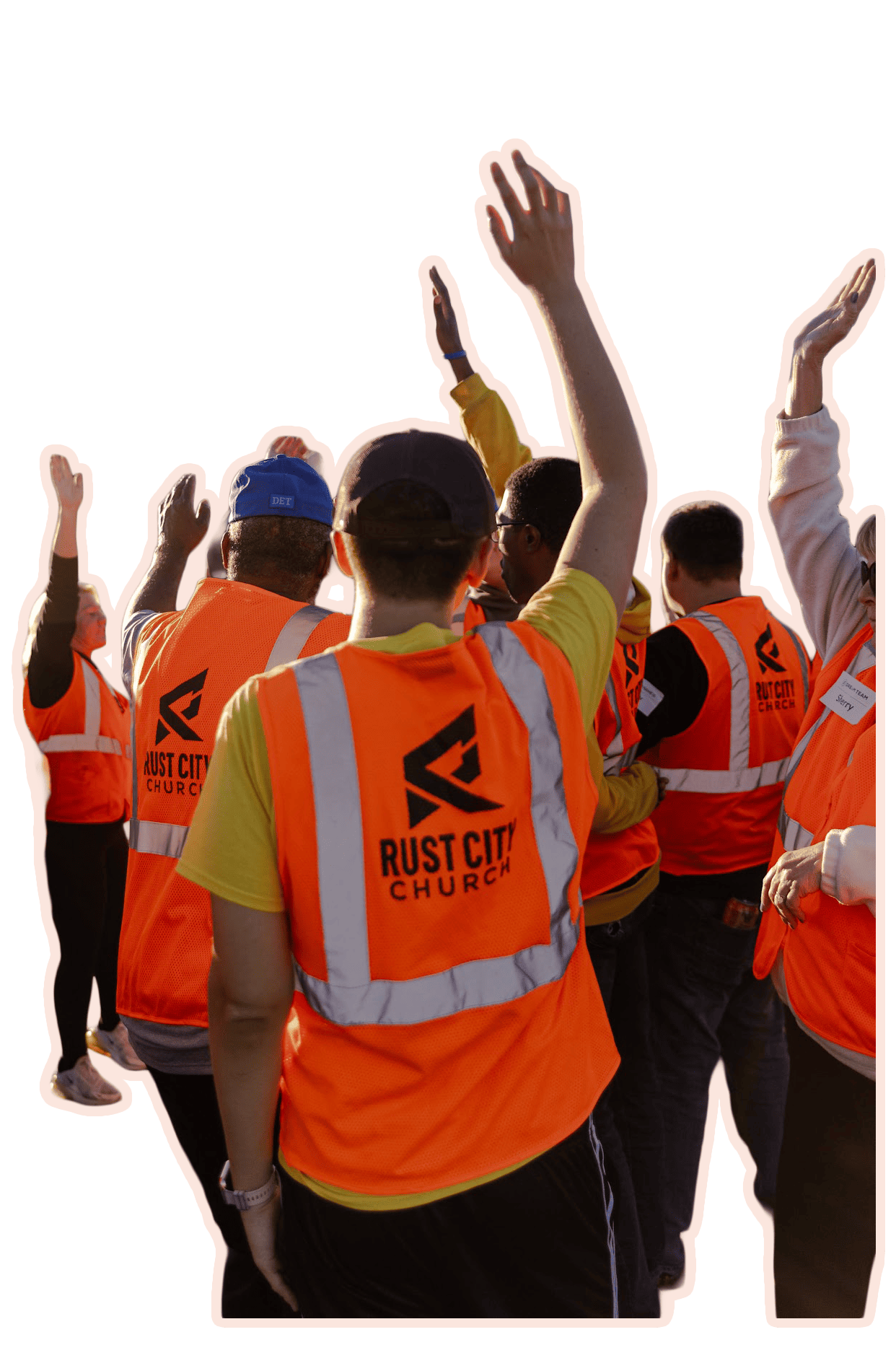 Group of volunteers wearing orange vests raising hands in the air
