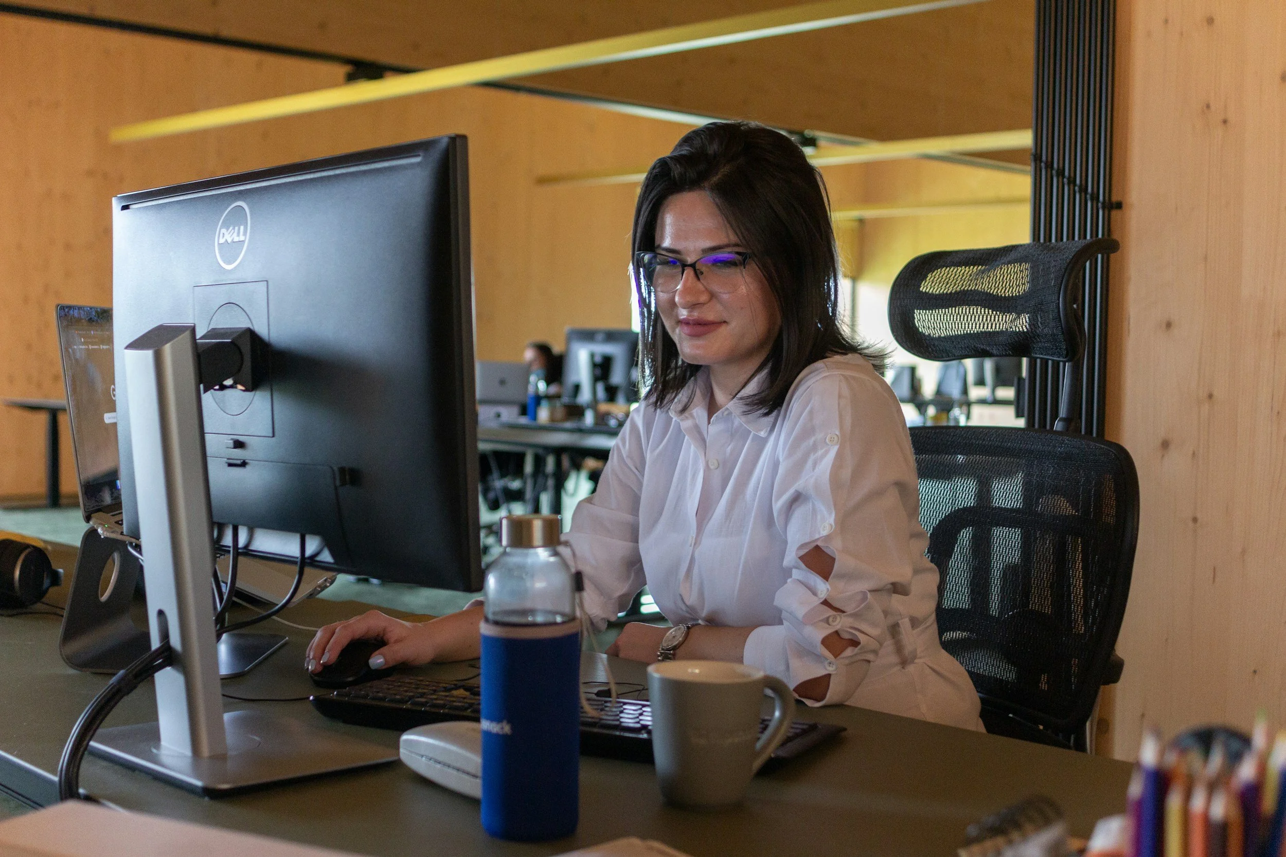 A recruiter sitting at a desk working on a computer in an office setting.