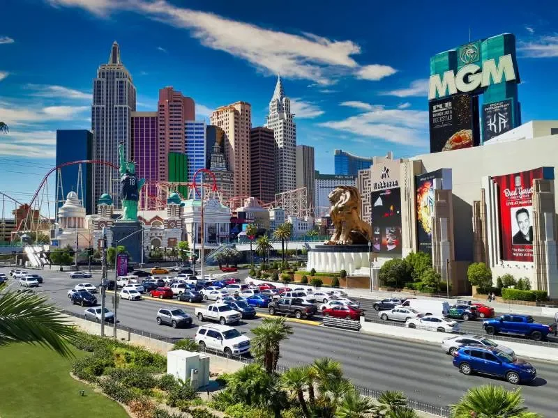 Las Vegas Strip with hotels, casinos, the MGM sign, and a busy street with cars.