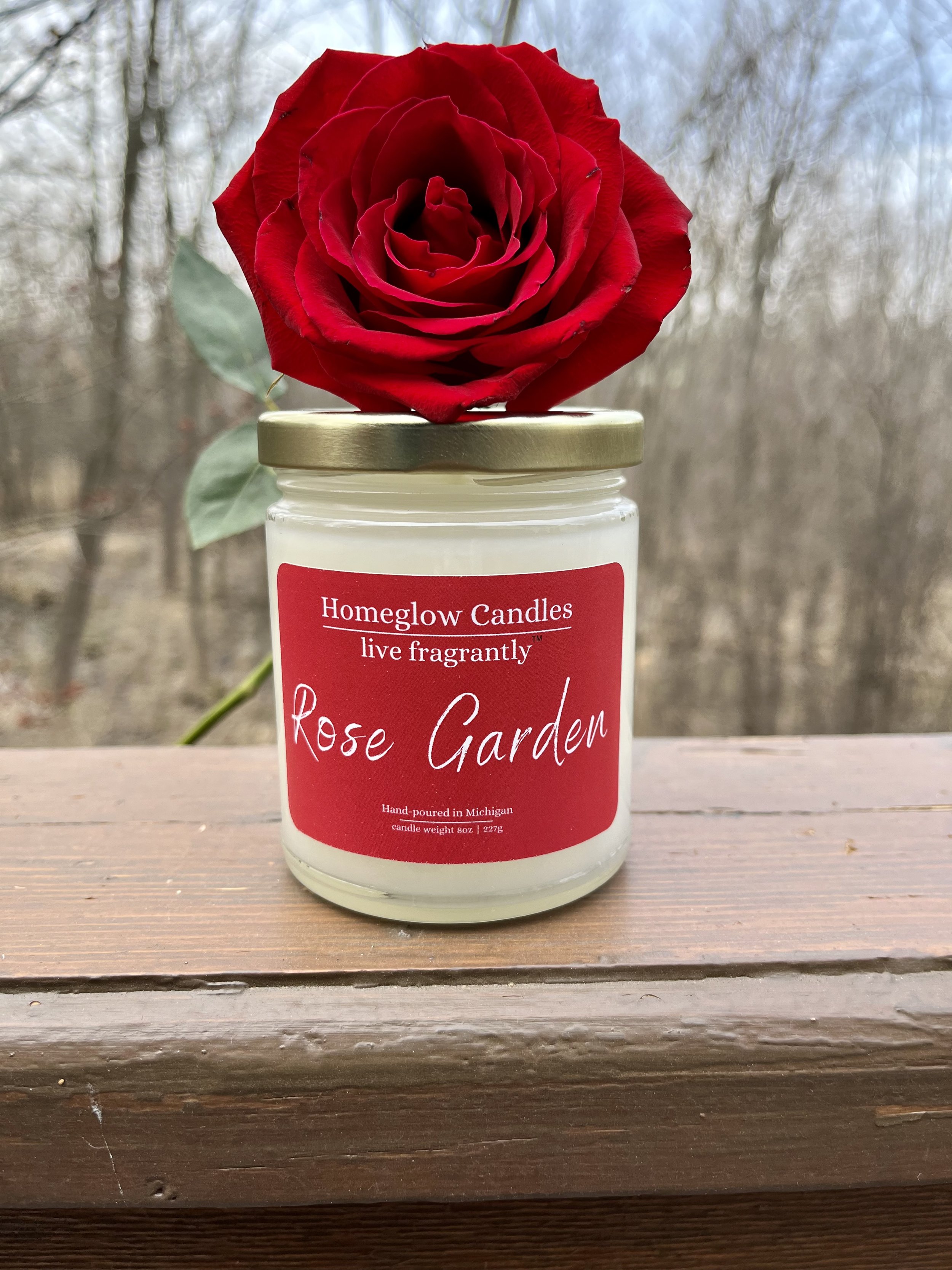 Rose Garden Candle with a fresh Rose laying on top of the candle
