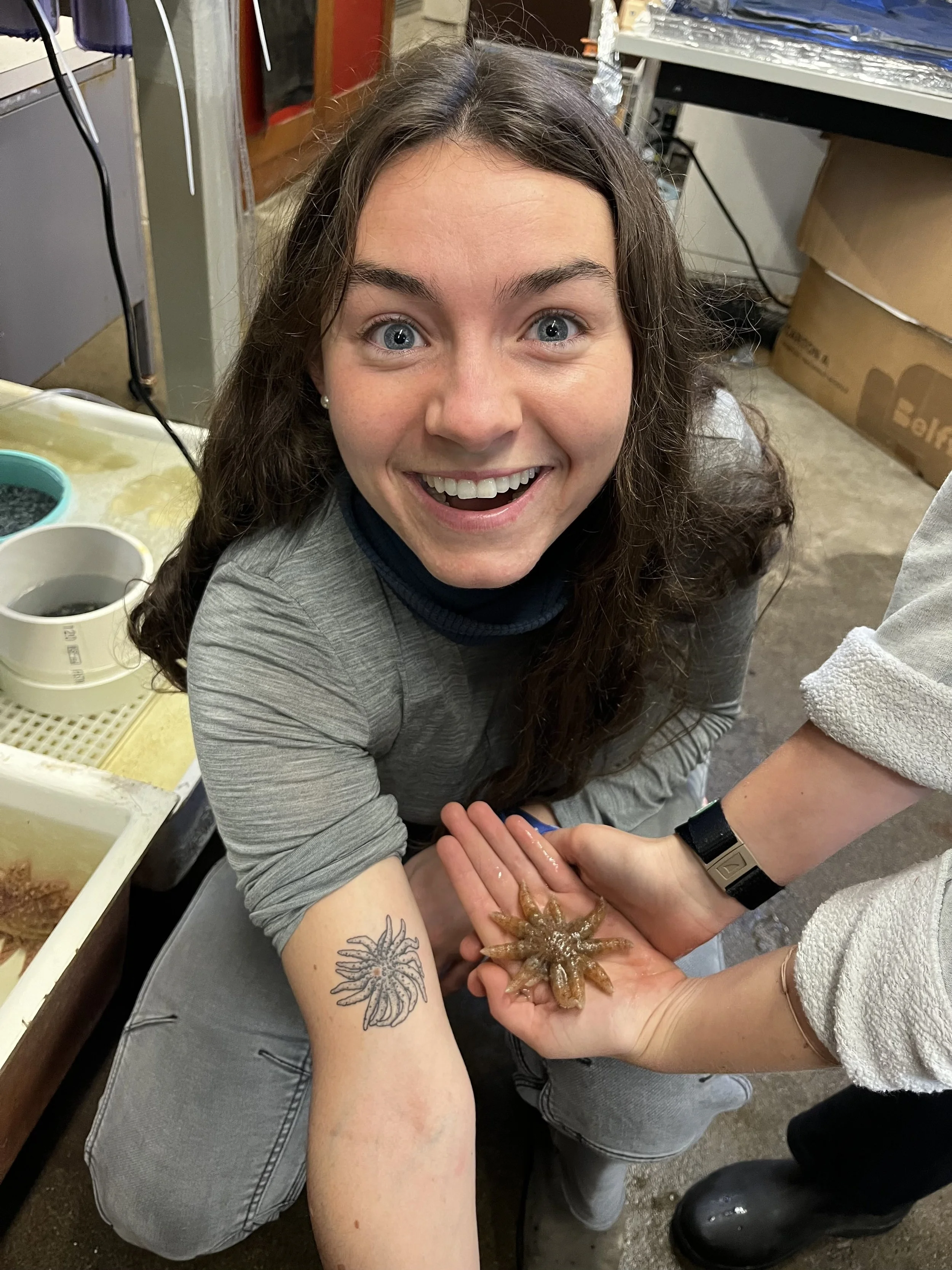 Abbey Dias posing with a sunflower star next to her sunflower star tattoo