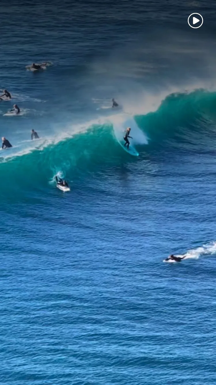 Surfers riding a wave on the North Coast
