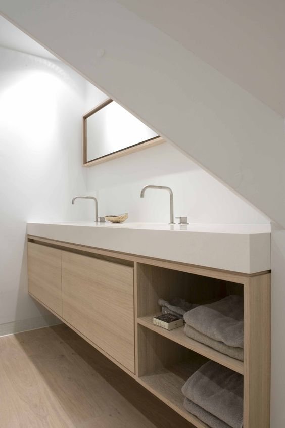 Bathroom with open timber vanity storage beneath an angled ceiling and small window.