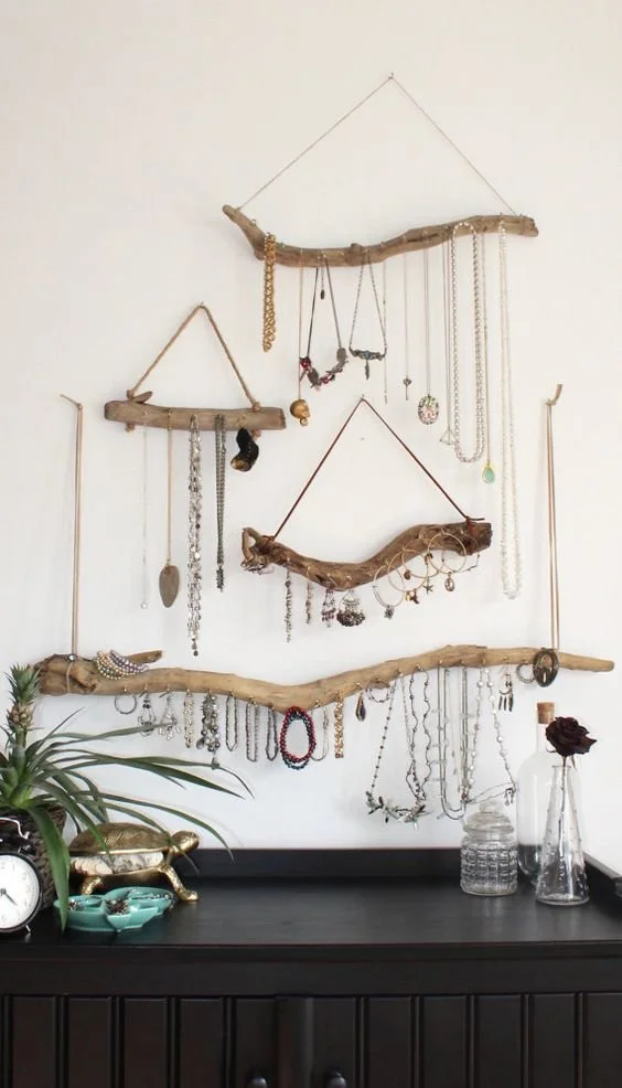 Jewellery and accessories arranged on decorative branch-shaped wall holders.