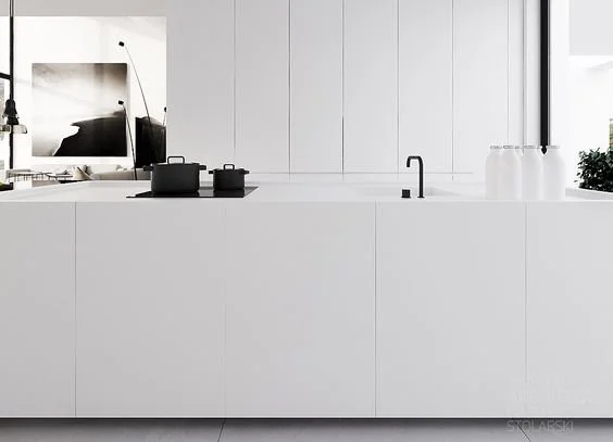Minimal white kitchen cabinetry with an integrated sink and slim tap.