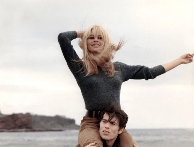 Outdoor portrait of a woman seated on another person’s shoulders.