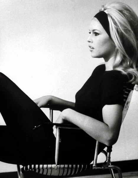 Black-and-white portrait of a seated woman wearing a dark top.