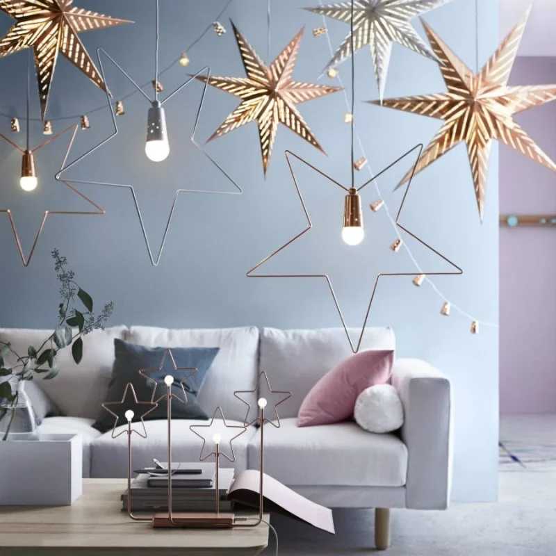 Hanging star decorations above a pale living-room sofa.