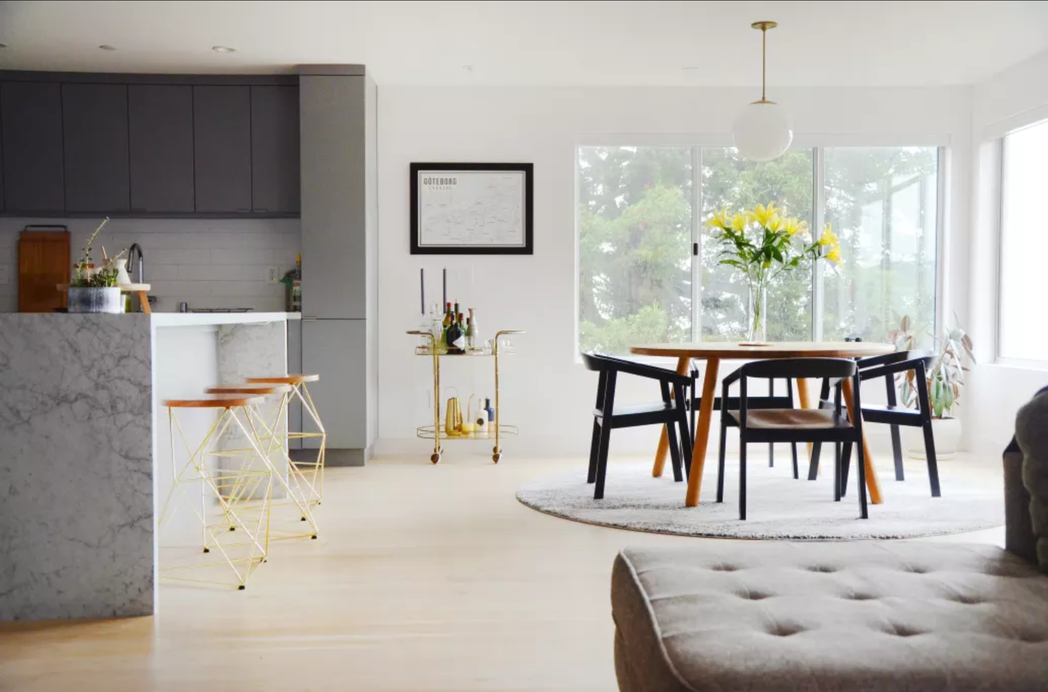Open-plan kitchen and dining room with pale flooring and garden-facing glazing.