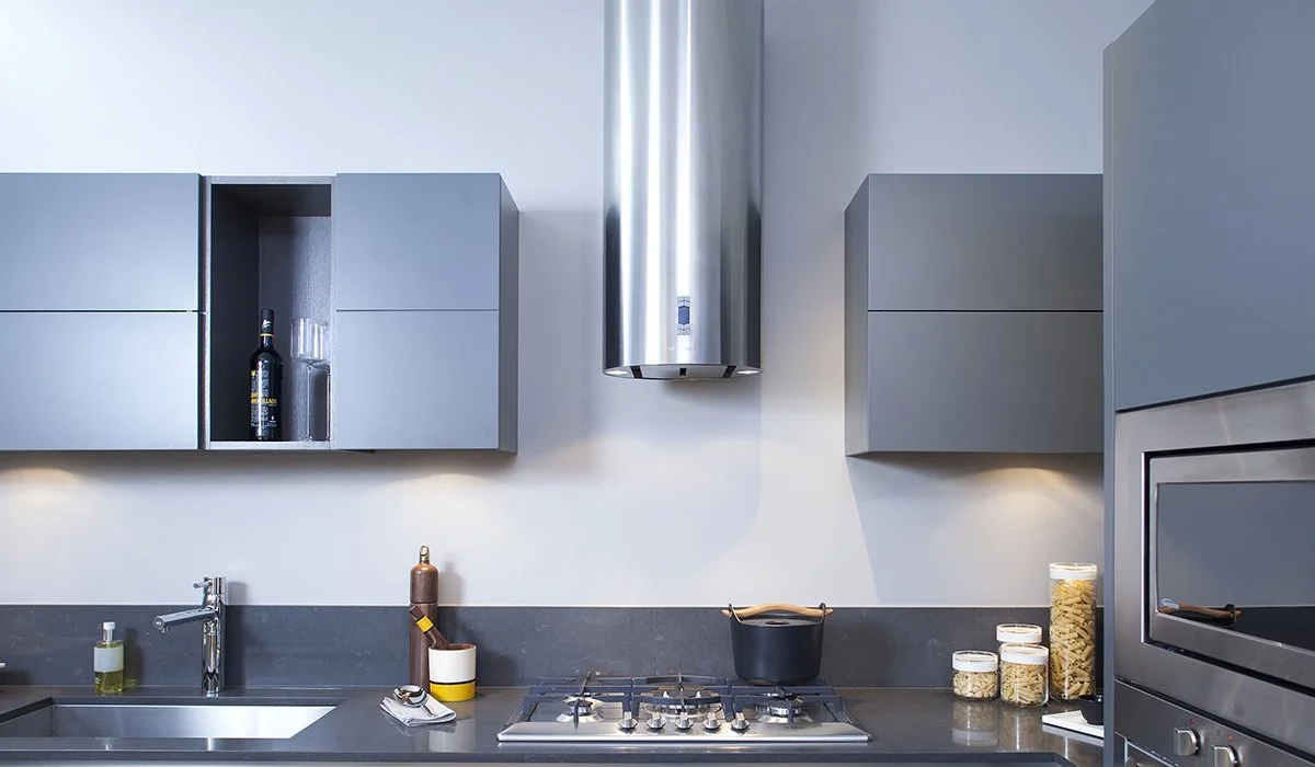 Kitchen with blue-grey cabinetry and a cylindrical stainless-steel rangehood.