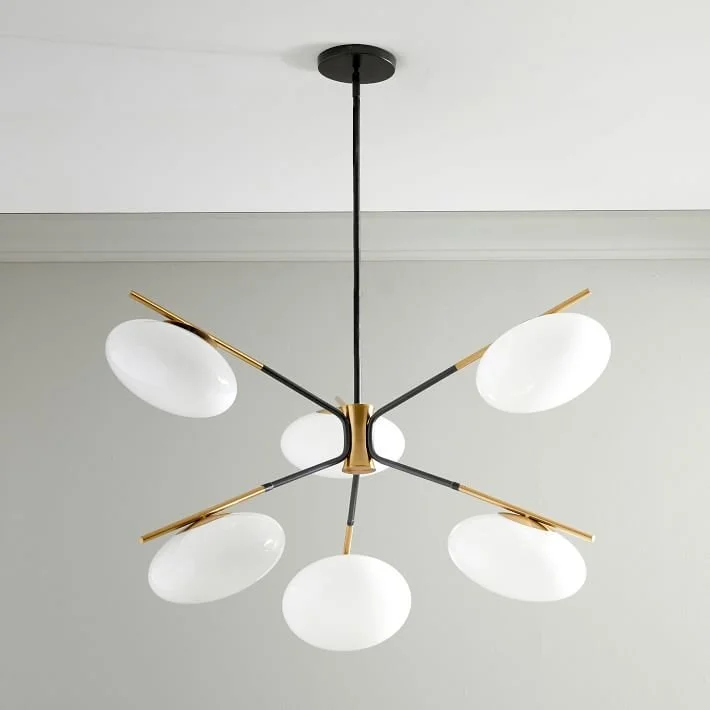 Branching pendant light with five white shades and brass-toned details.