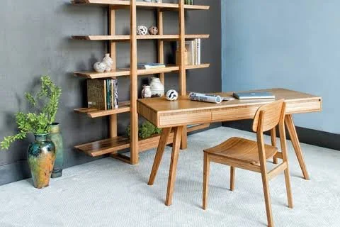 Timber dining table and chair beside open timber shelving and plants.