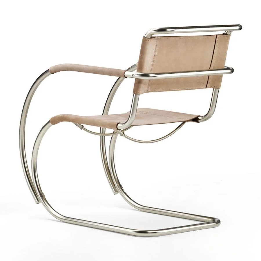 Tan sling chair with a curved tubular metal frame.