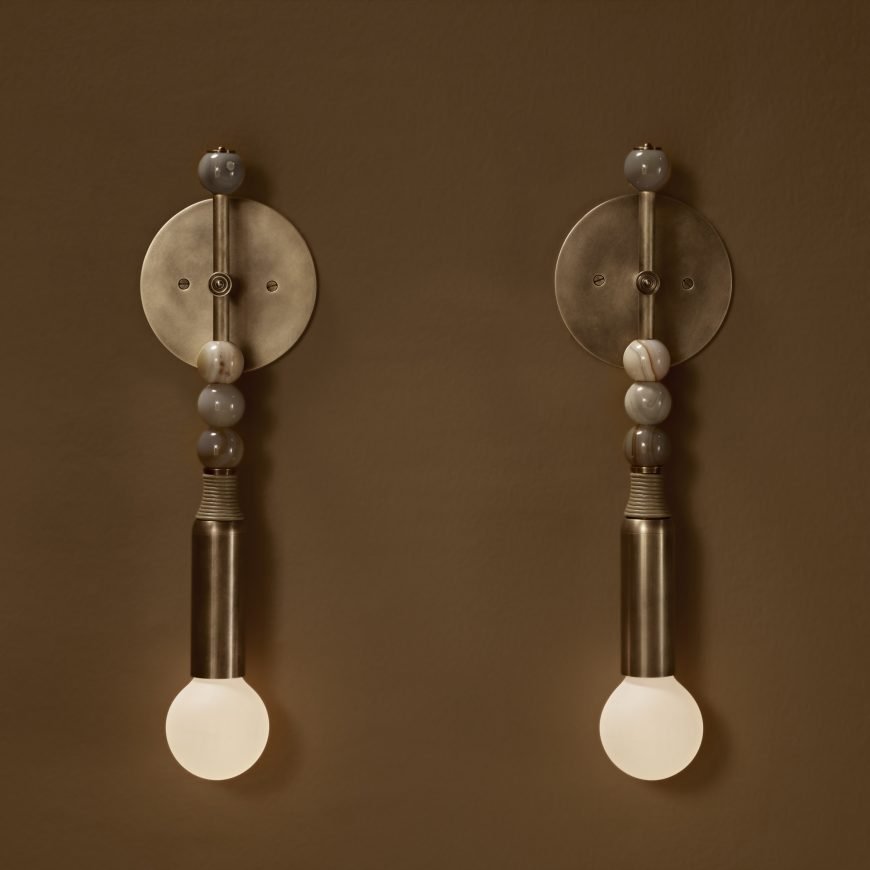 Paired decorative wall lights with brass-toned discs and white globes.