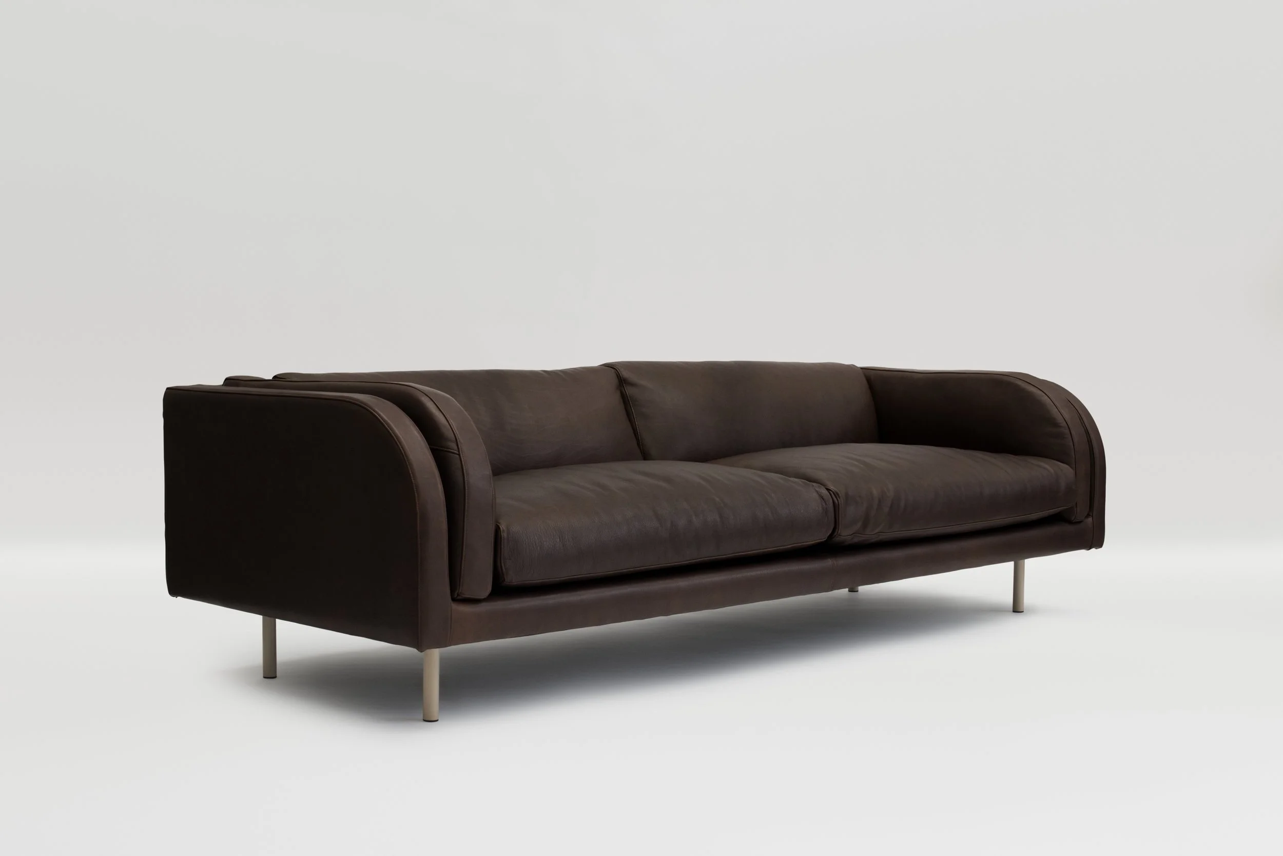 Dark brown sofa with rounded arms and slender metal legs.