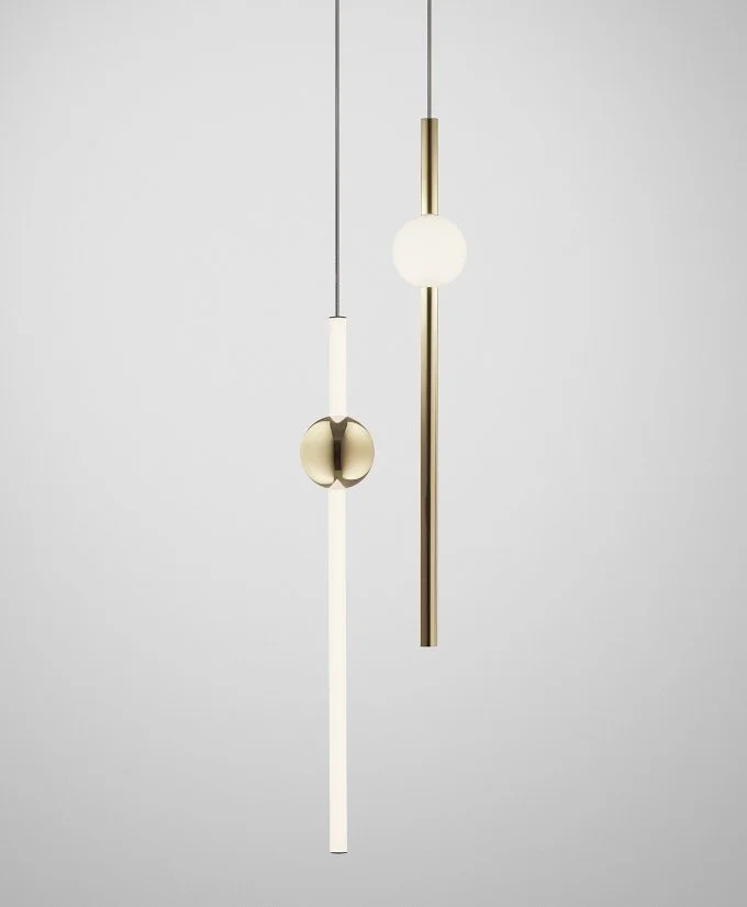 Slender pendant lights with brass-toned elements and white globes.