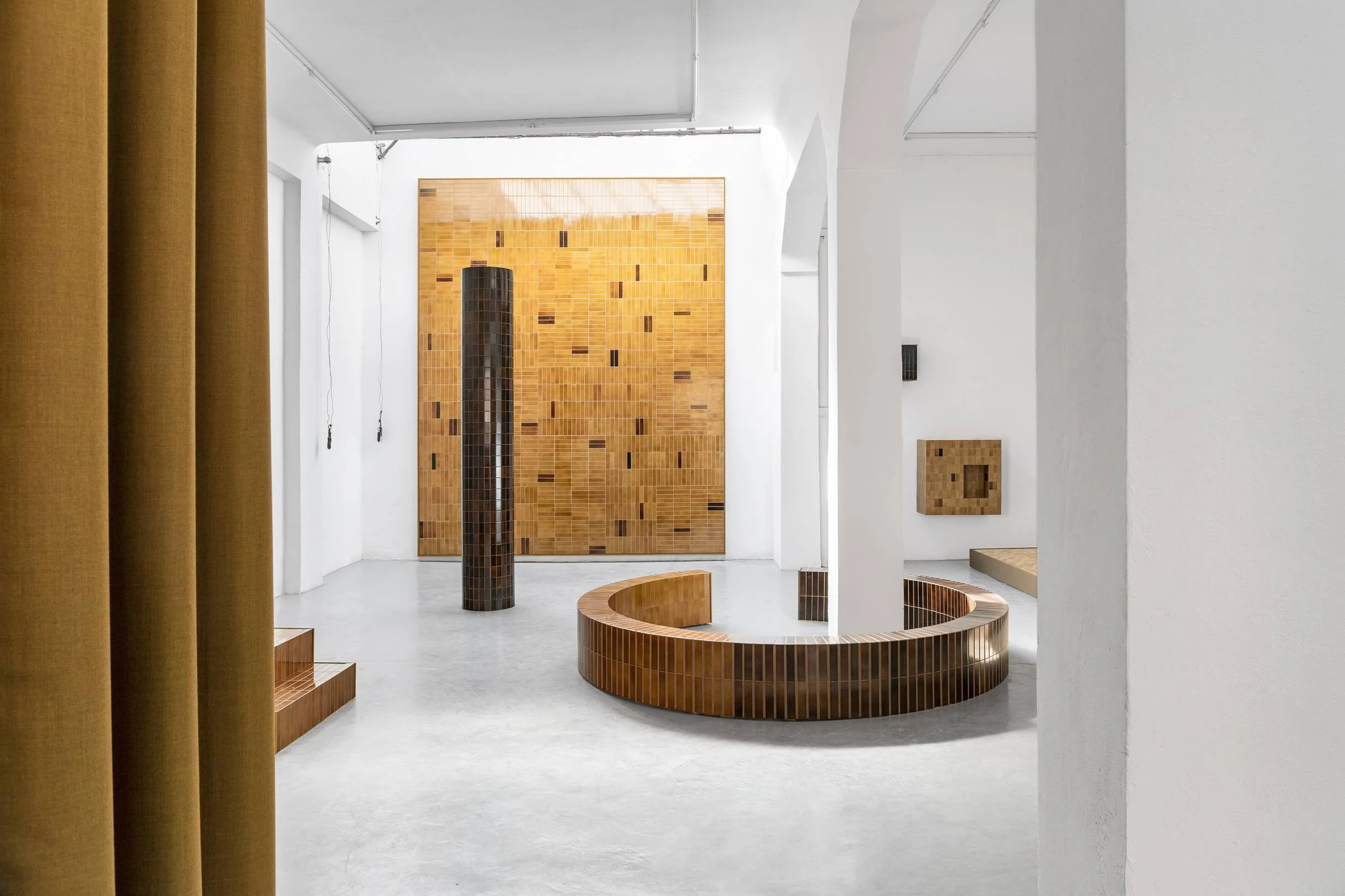 Light bathroom with a round sunken bath and warm patterned wall tiles.