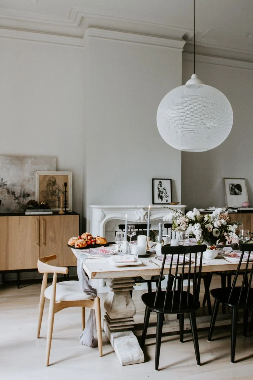 Dining room with timber furniture and a round white pendant.