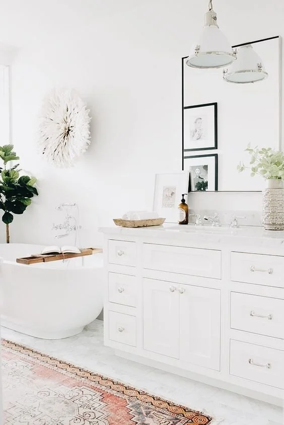 Pale cabinetry and sculptural stool above a warm-toned patterned runner.