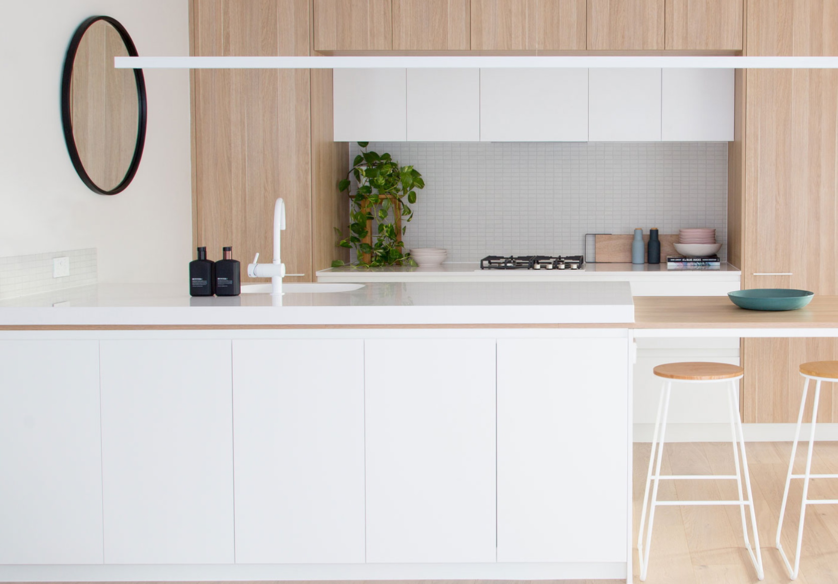 Pale kitchen island framed by timber joinery with a slim horizontal light.