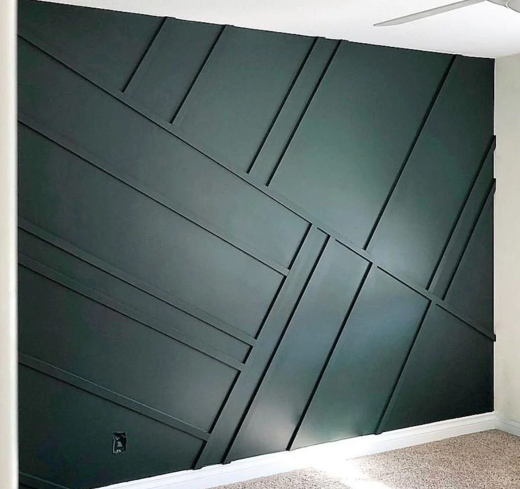 Dark green wall with intersecting raised linear panelling.