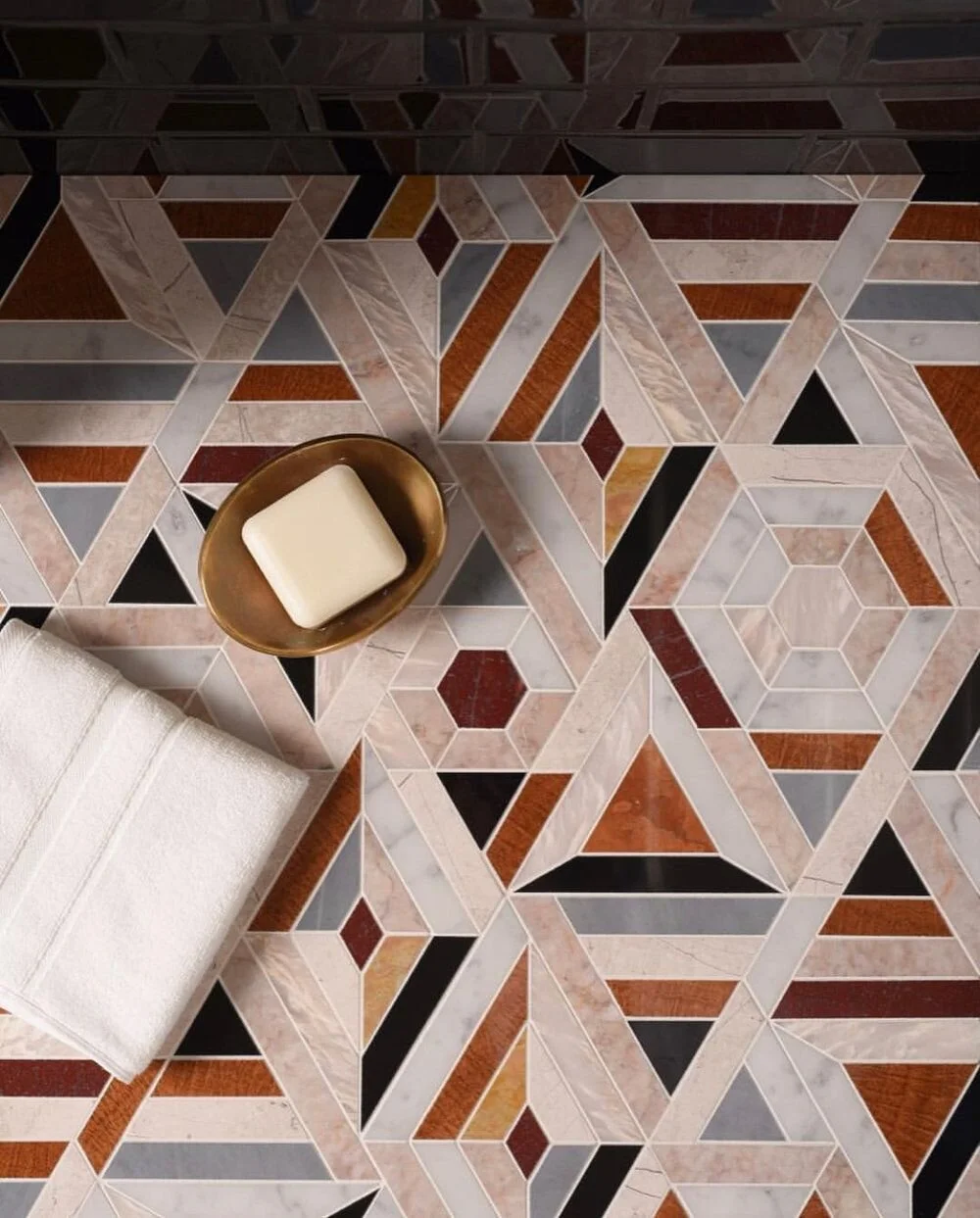 Geometric patterned floor beneath a small table and pale seating.