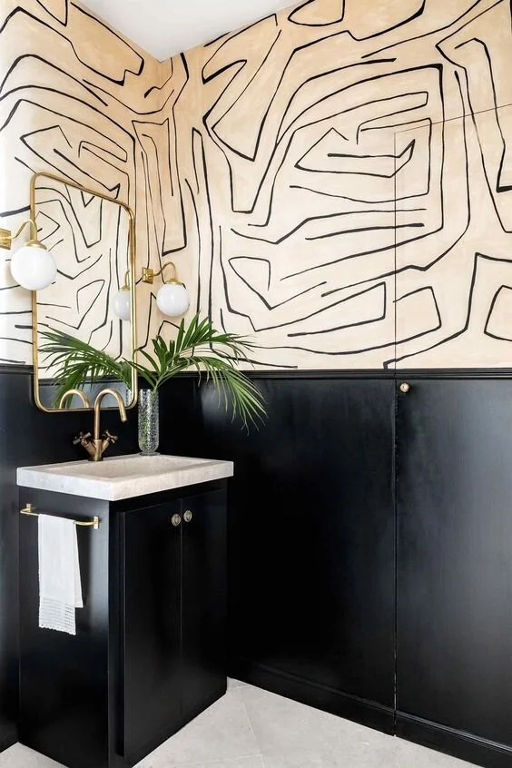 Abstract line-patterned wallpaper above dark wall panelling and a small side table.