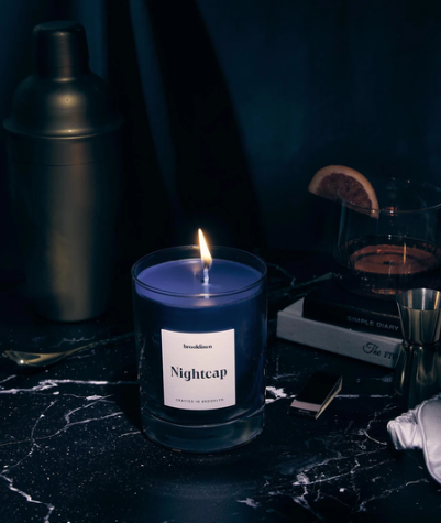 Lit blue candle vessel on a dark surface.