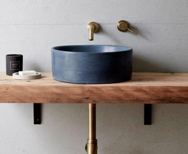 Blue countertop basin on a timber vanity with brass-toned wall taps.