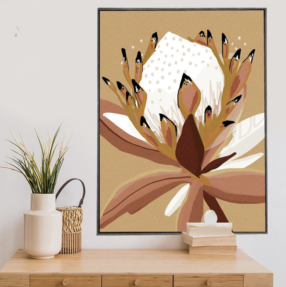 Framed botanical artwork with a warm earthy palette above a timber cabinet.