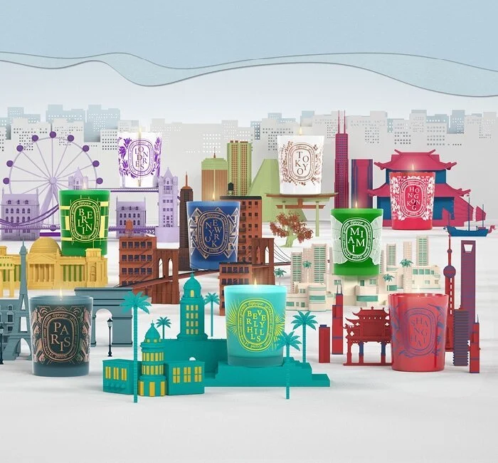 Colourful boxed fragrance products arranged against a pale blue background.