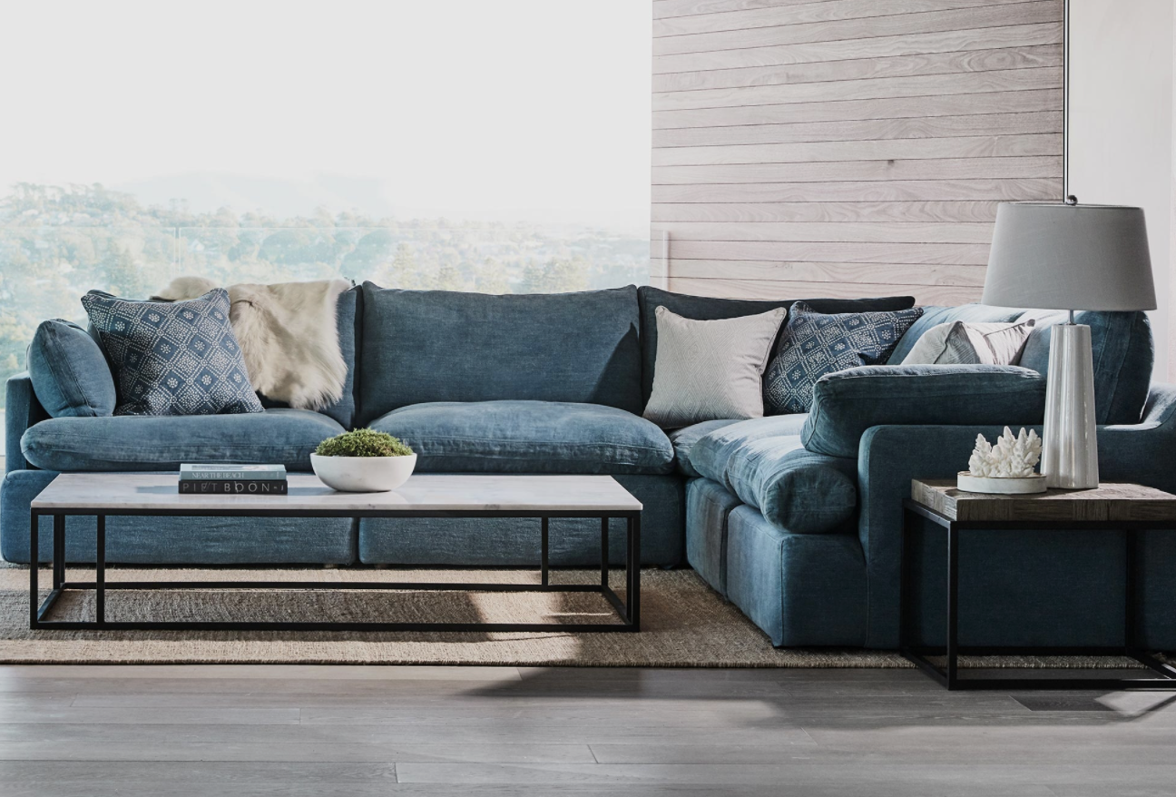 Deep teal modular sofa with cushions beside a low rectangular coffee table.