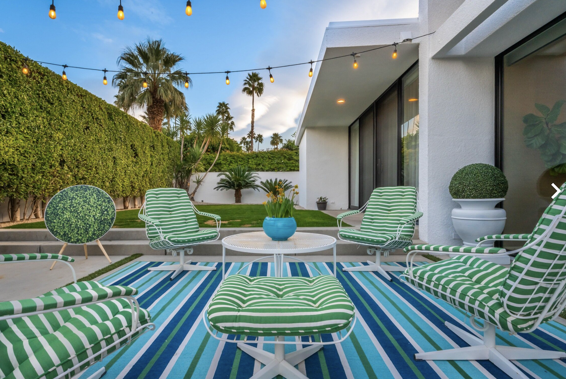 Green striped outdoor seating on a blue striped terrace rug.