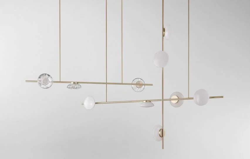 Sculptural brass-toned pendant with varied white and clear globe lights.