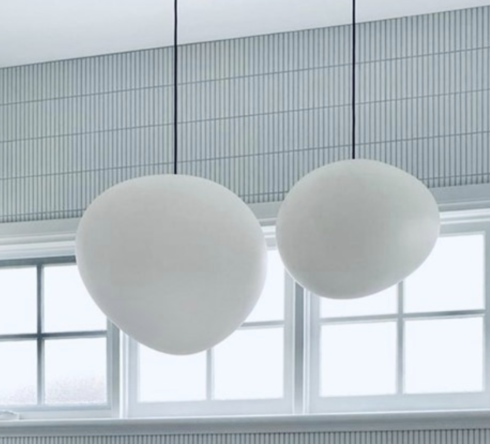 Two white globe pendant lights beside a tiled wall and window.