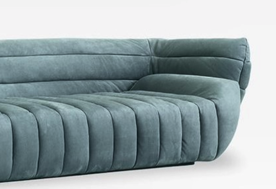 Blue-grey curved sofa with ribbed upholstery, shown against a white background.