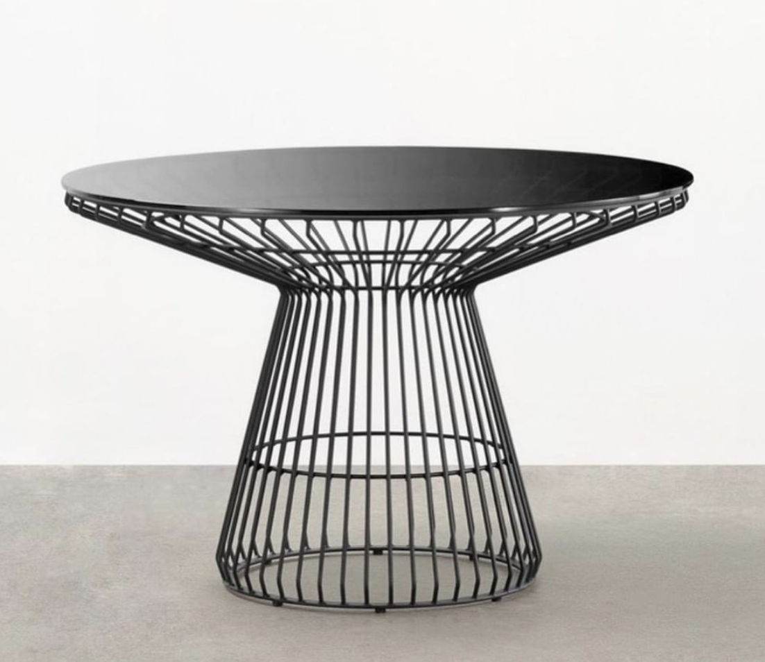 Round black dining table with an open wire base, shown against a white background.