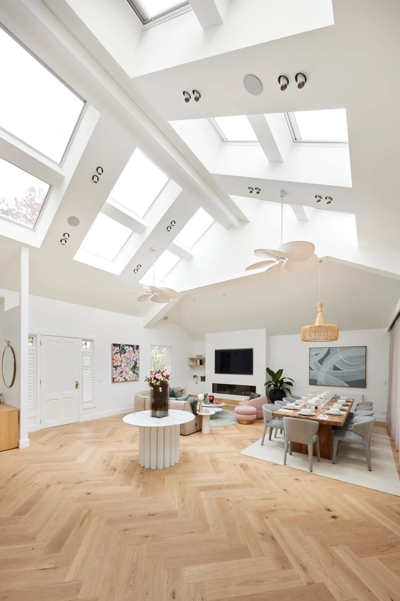Open-plan interior with high pitched ceilings, skylights and timber flooring.