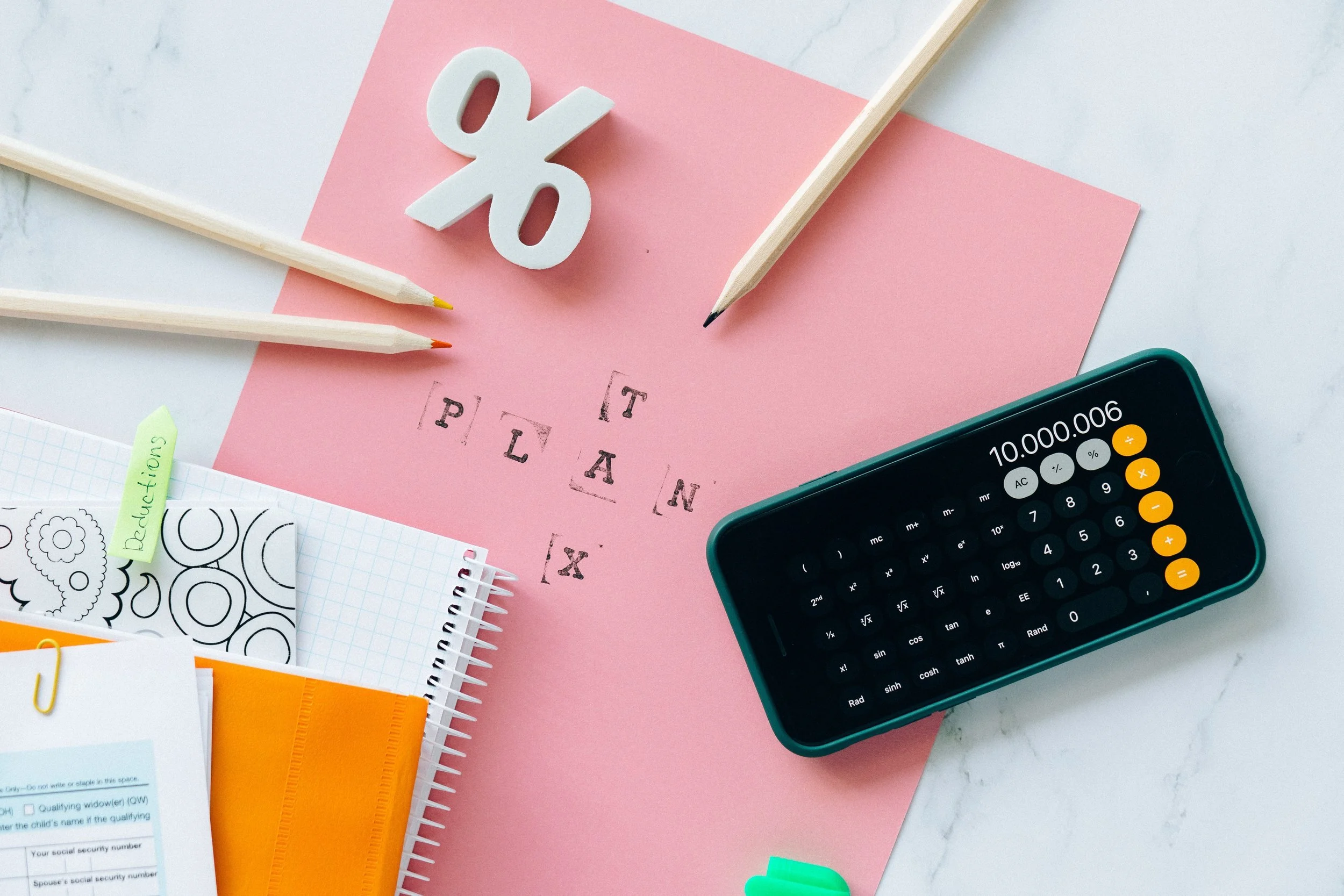 Calculator, notebook and pencils arranged for renovation budget planning.