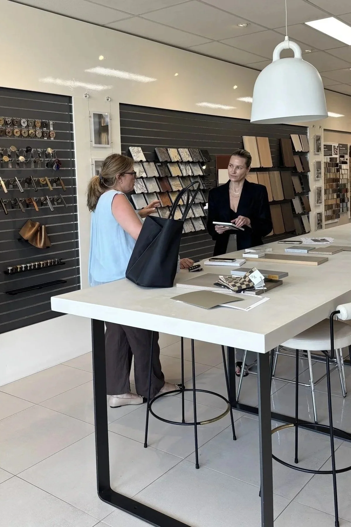 interior designer and client discussing material samples at the essendon studio consultation bench.