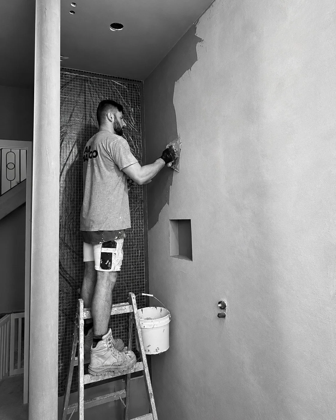 A specialist trade applying a textured wall finish during construction of Alpine House.