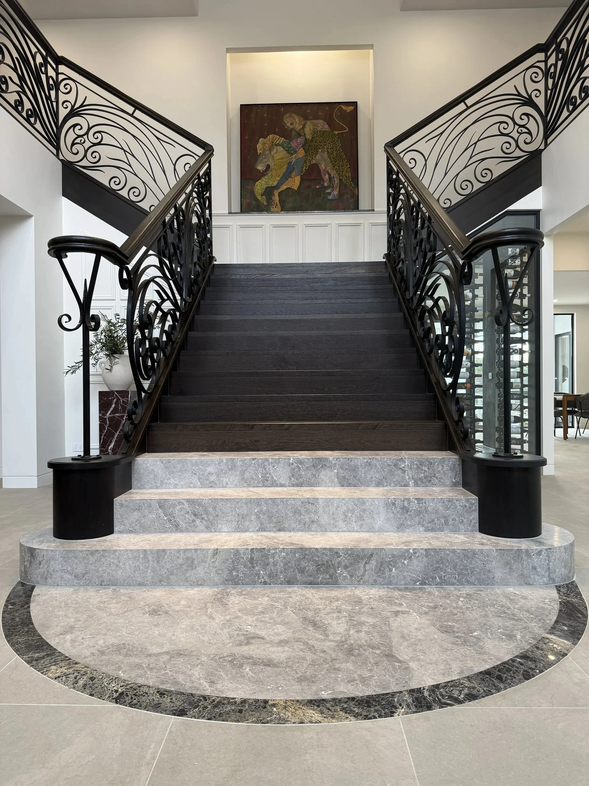 Stone staircase with ornate dark metal balustrades and decorative posts.