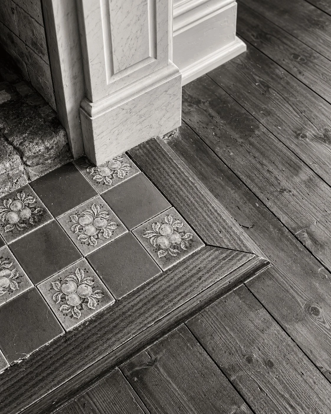 Craigneal material samples arranged on timber flooring beside a period skirting board.