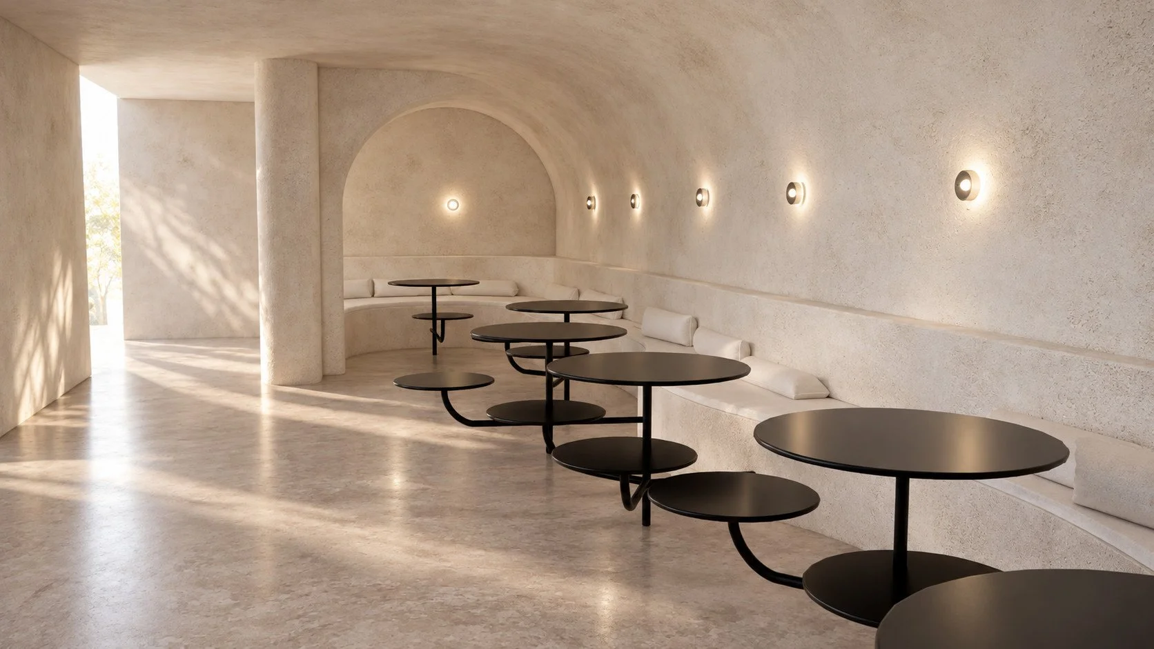 curved rendered walls and an arched recess frame the perimeter seating, with polished concrete floors and a restrained sandy palette.