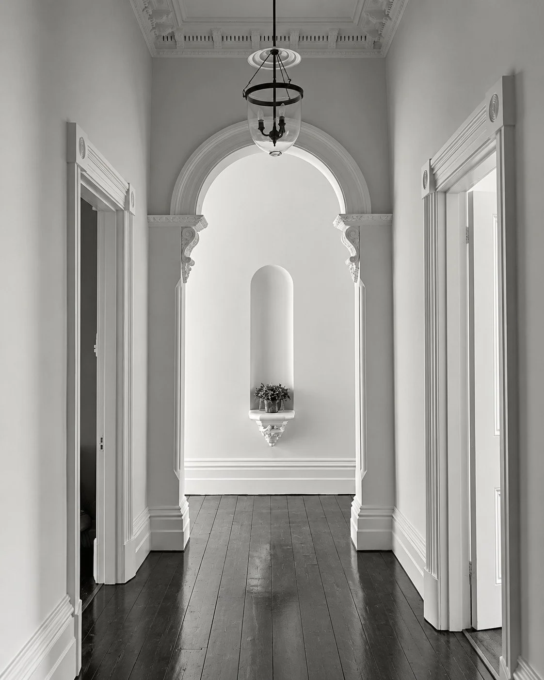 Craigneal entrance hallway with an arched opening, pendant lighting and period detailing.