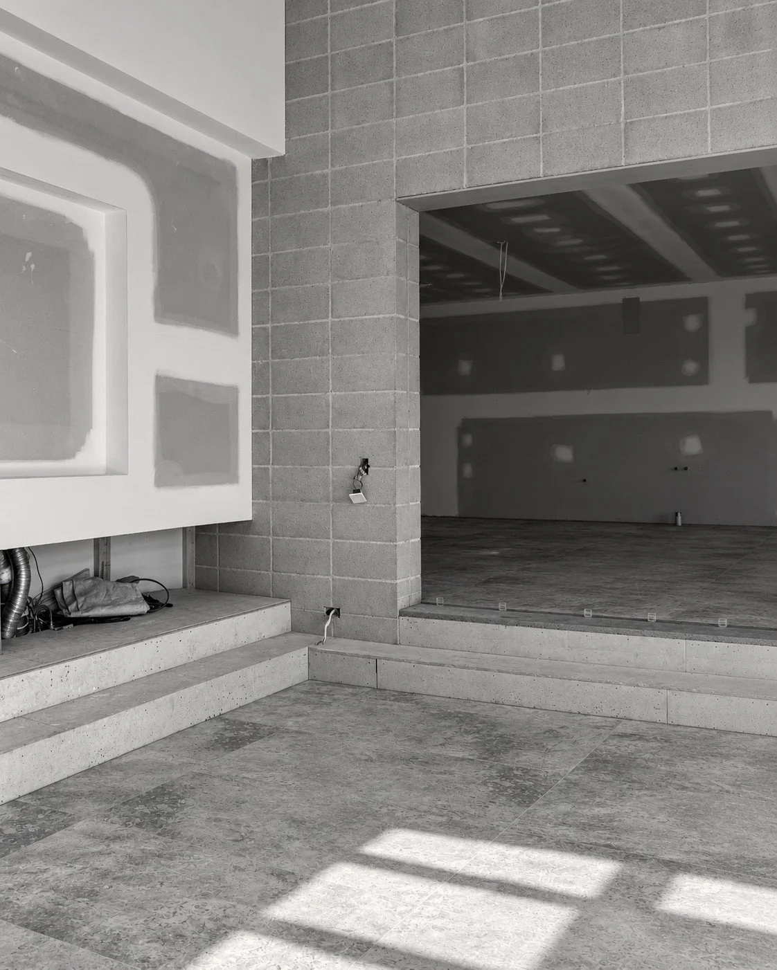 Lorde House living area under construction with a framed fireplace recess and adjoining windows.