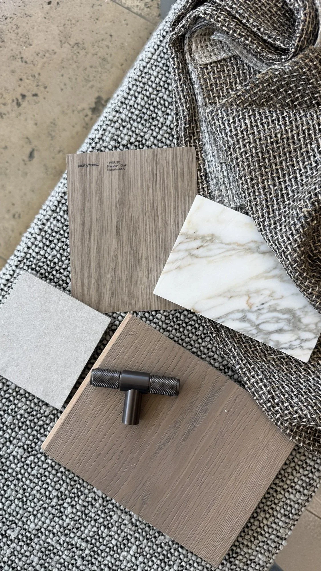 timber, stone and textile samples arranged as a neutral interior materials palette.