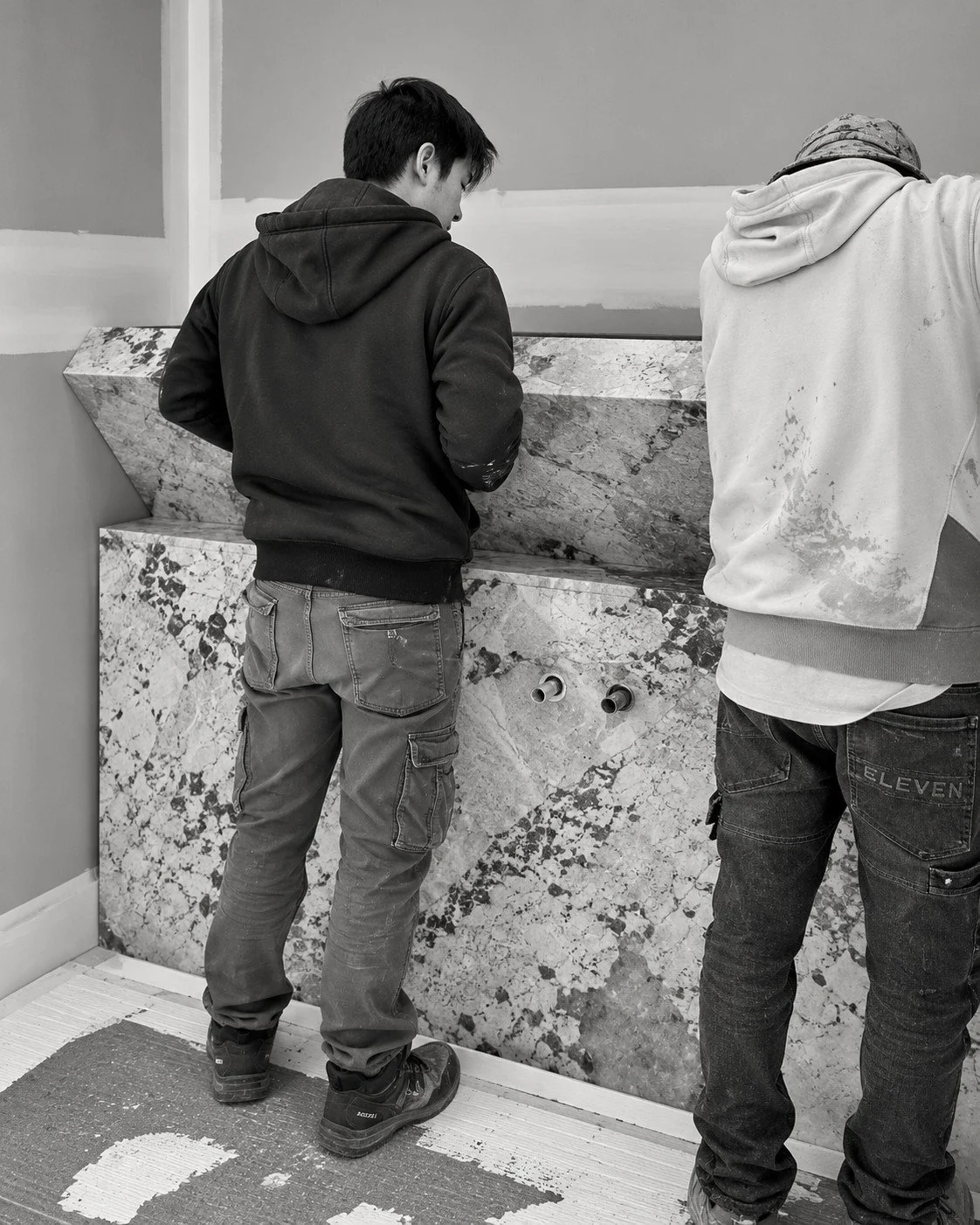 Designers reviewing a natural stone slab together for the Alpine House interior palette.