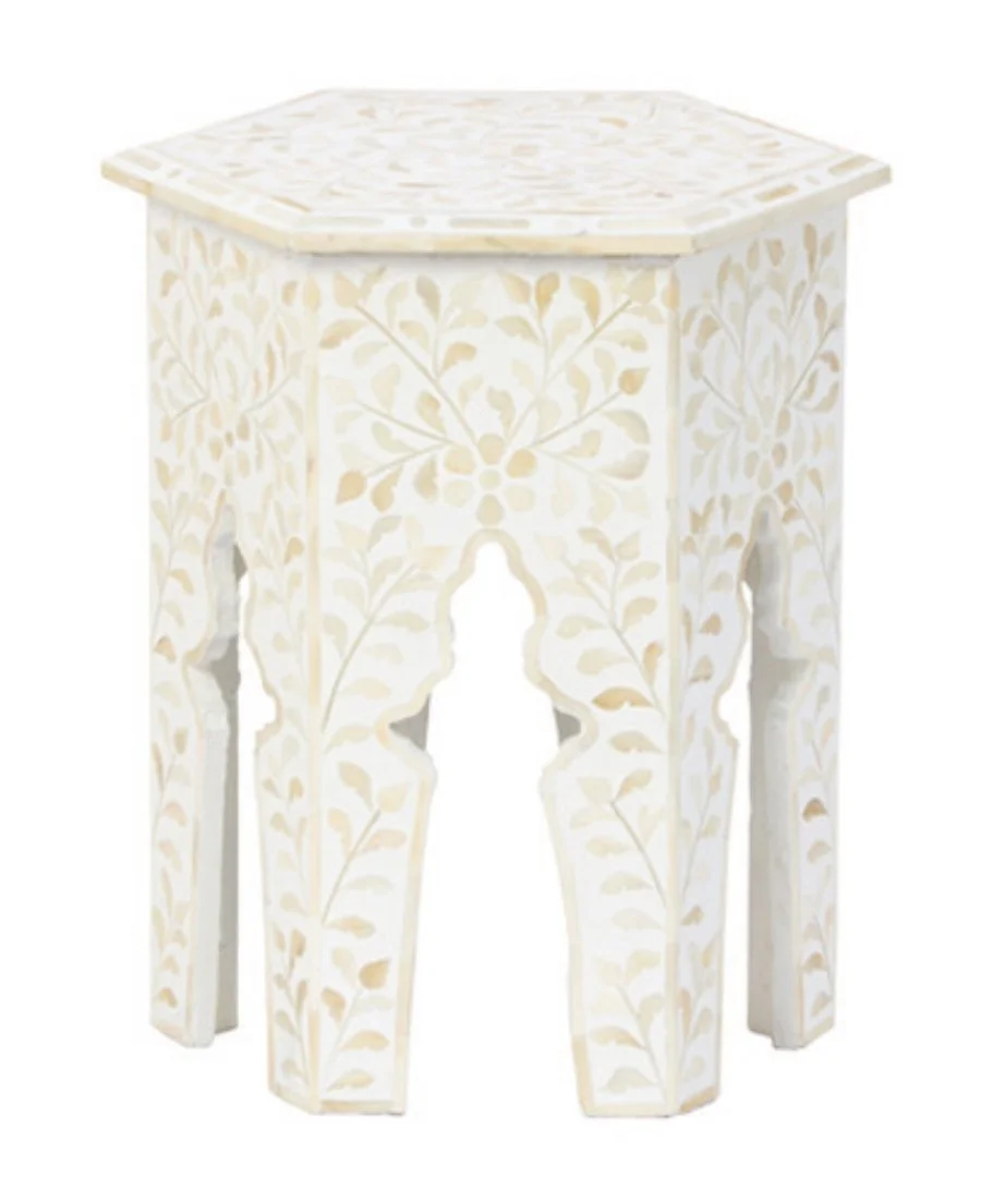 Pale decorative side table with intricate carved geometric openings.