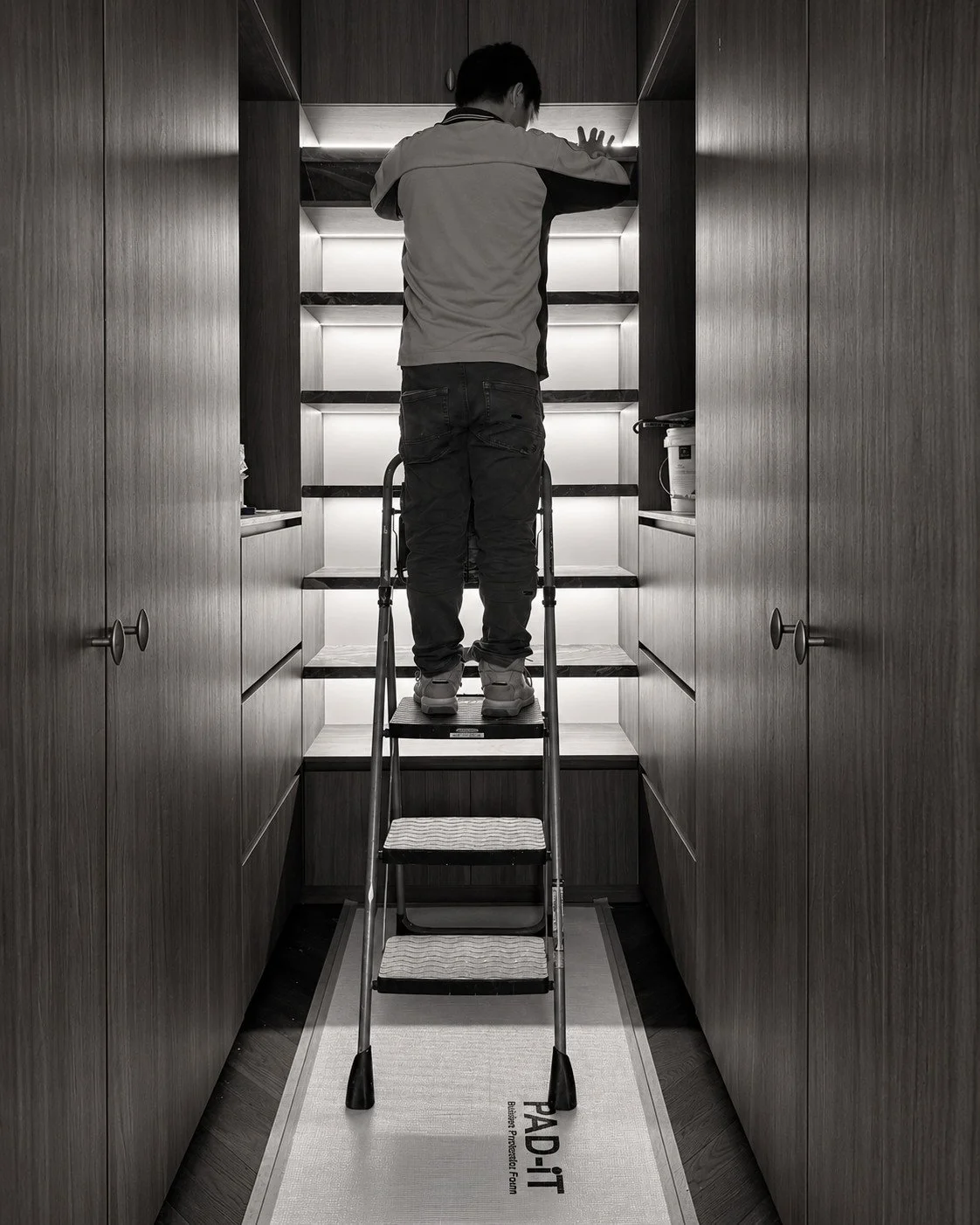 Alpine House walk-in storage under construction, with tall joinery and illuminated open shelves.
